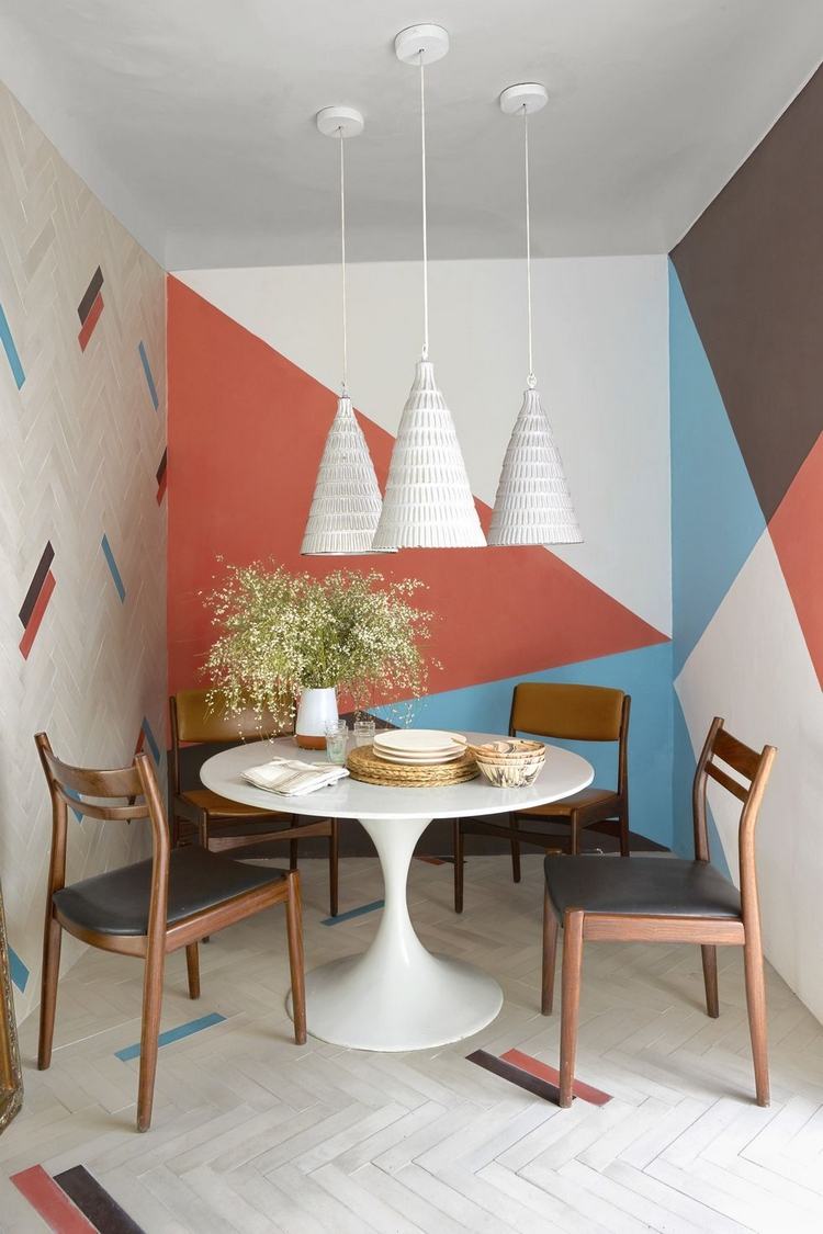 70 -talets retrolook och färgglada geometriska väggmönster med trästolar vid det runda matbordet