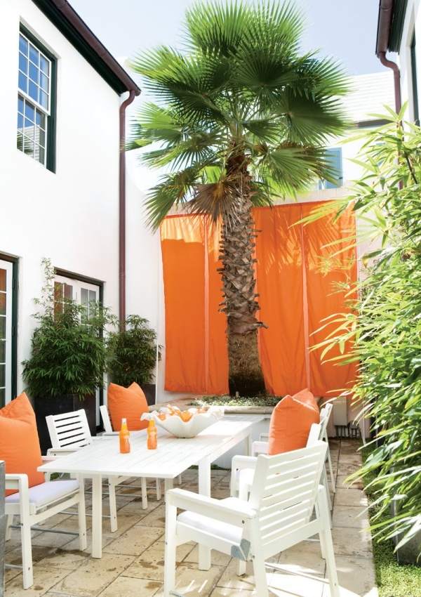 Utomhus matplats vita möbler orange kuddar sekretess skärm