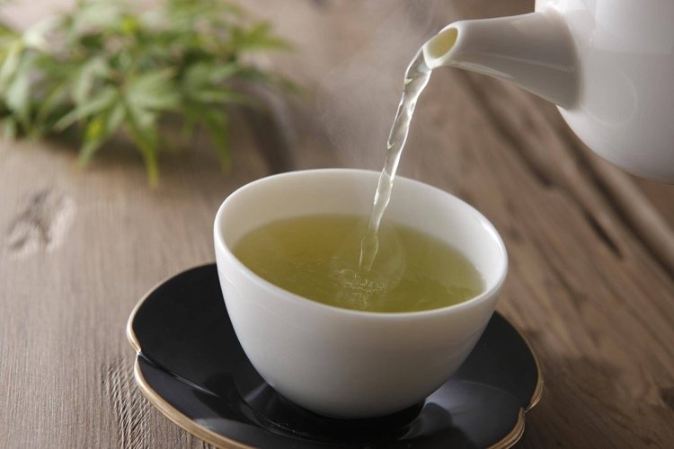 Friska pick-me-ups dricker grönt te istället för kaffe för att öka din ämnesomsättning