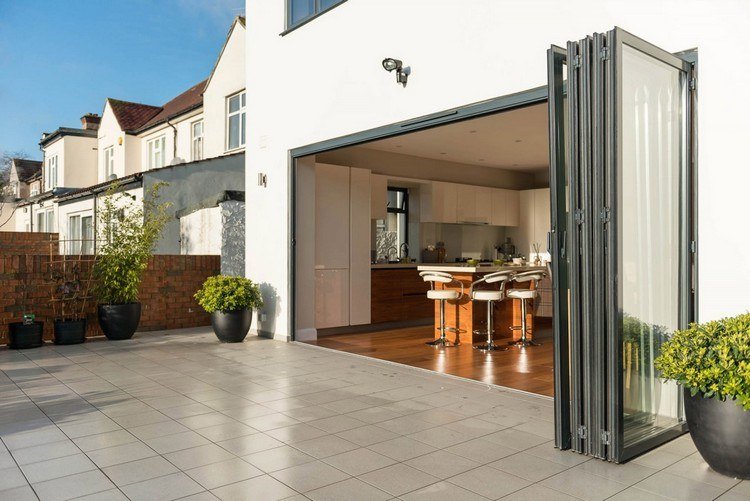 Fällbara glasdörrar för terrassfällnings-vägg-öppning-till-utsidan-terrass-kakel-växter