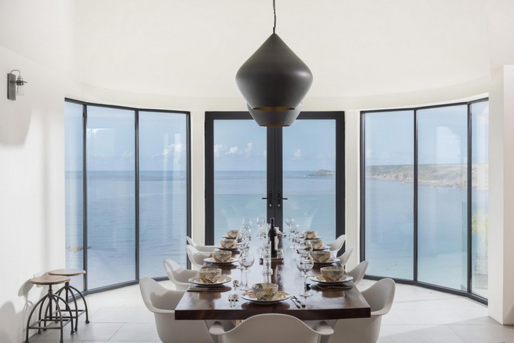 glas-fram-matplats-rektangulärt-matbord-vita-stolar-svart-taklampor