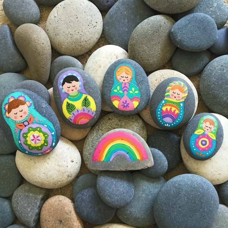 Vuxen matryoshka och regnbåge på platta stenar