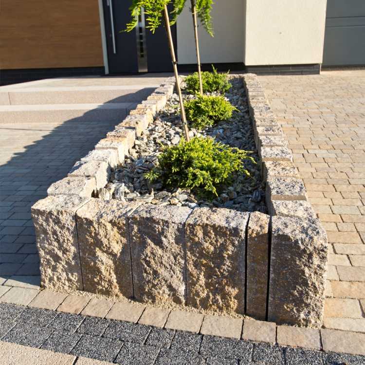 granit-palissad-stenar-gröna-buske-beläggningsstenar