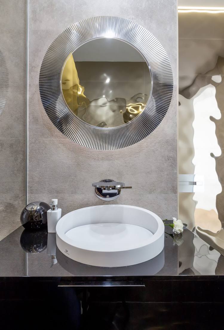 grå inredning badrumsbänk modern högblank spegel rund