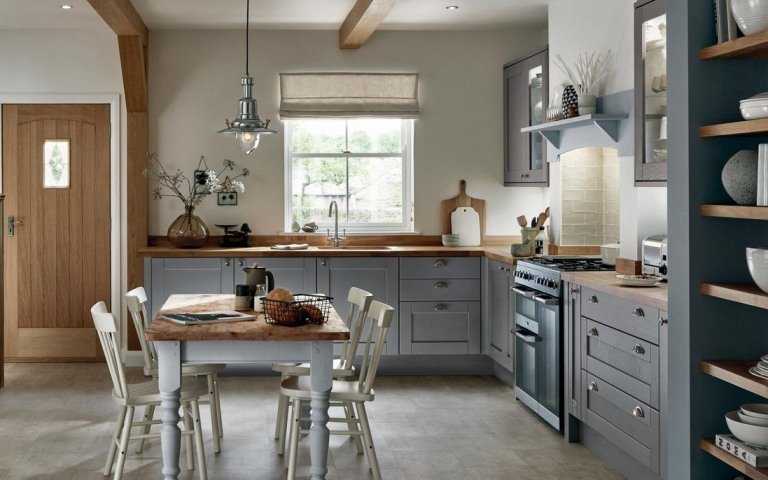 Ljusgrått kök med bänkskiva i trä och ljus väggfärg