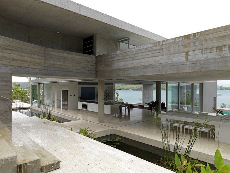 Begränsat levande koncept hus-betong-sten-dammar-öppna-vardagsrum