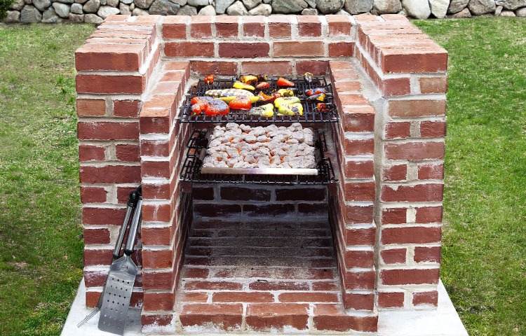 Tegelgrill bygga själv murverk med grillrist och kol i trädgården
