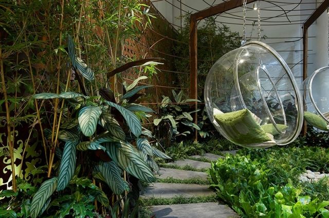 bubbla-hängande-stol-frodig-plantering-trädgård