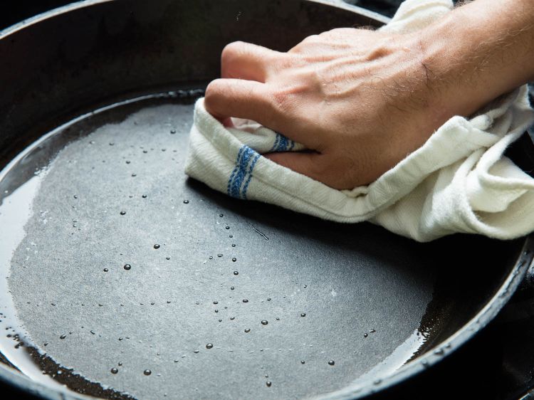 rengöring och skötsel av gjutjärnspannan praktiska tips tricks köksrengöring köksredskap torkduk låter vätska tas bort över natten
