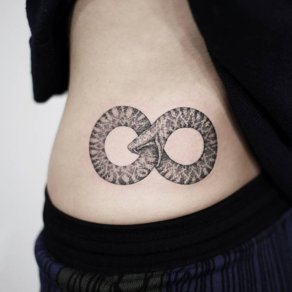 ouroboros tatuering på en kvinnas höft som en egyptisk symbol för oändlighet och evigt liv