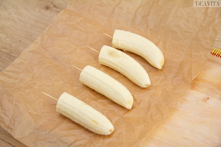 Halloween recept för fingermat skär bananer i hälften och stick en tandpetare