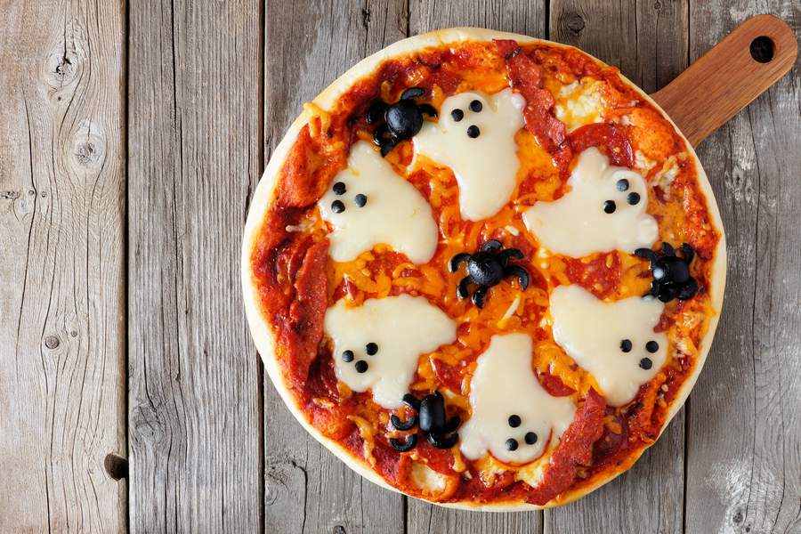 Klassisk rund pizza med spöken och spindlar till halloweenfesten