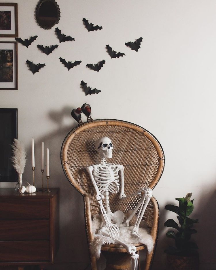 Skelett sitter i en påfågelfåtölj - Boho Halloween