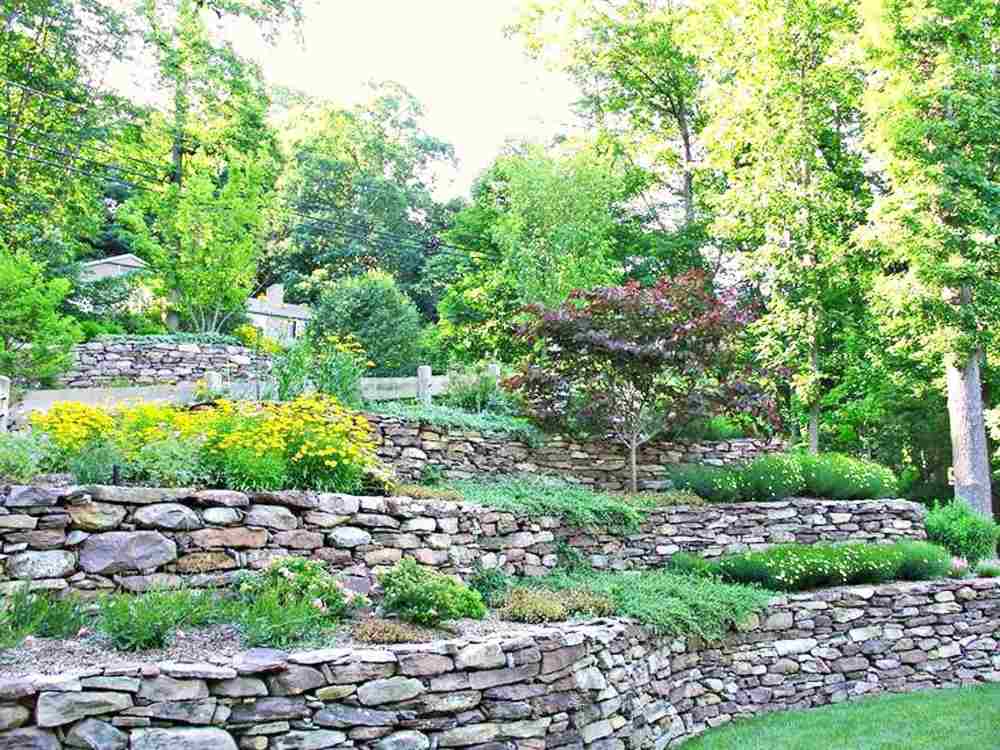 Skapa en terrassad trädgård och säkra sluttningen med stenar och förhindra erosion