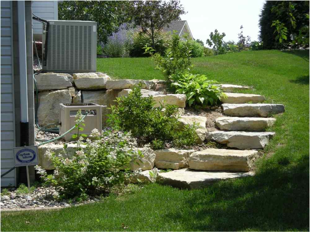Bakgård med trappor av sten och gräsmatta för att säkra sluttningen