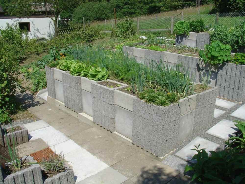 betongpalisader lutningsfäste fönsterluckor med växter i trädgården