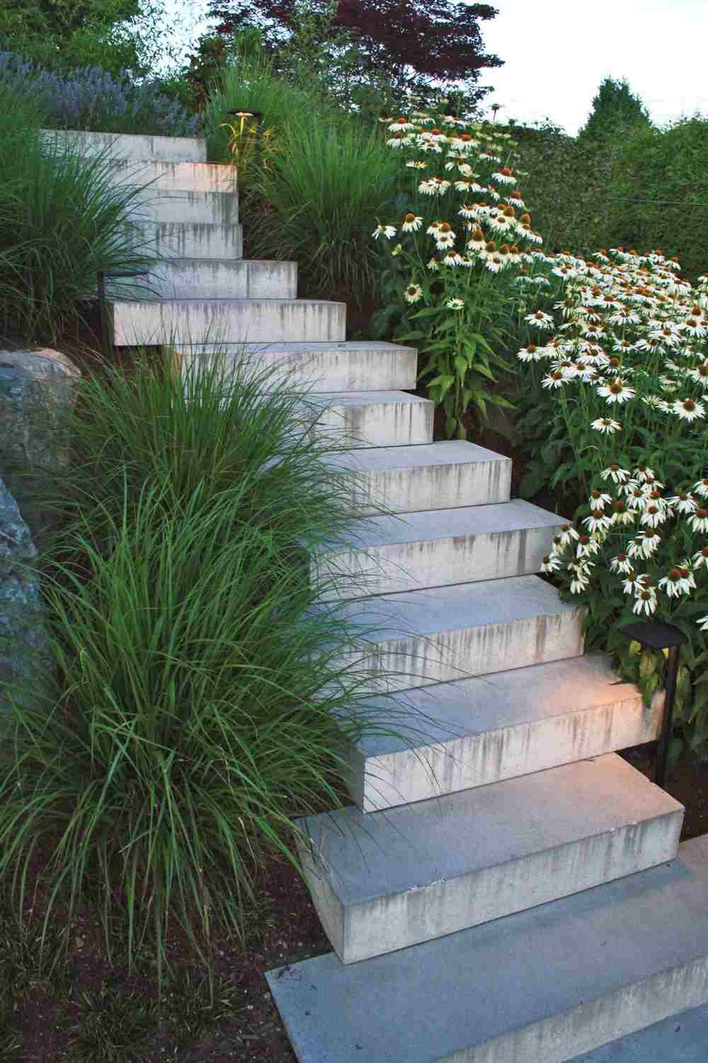 kreativ sluttningsstabilisering gjord av betongtrappor och gröna växter med blommor för trädgården
