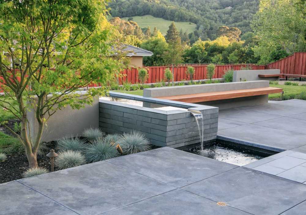 modern designad trädgård med betonglutning och vattenfunktion