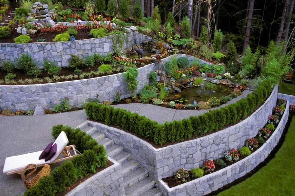 betongplattor sluttande fixering och terrassering i trädgården med vackra växter