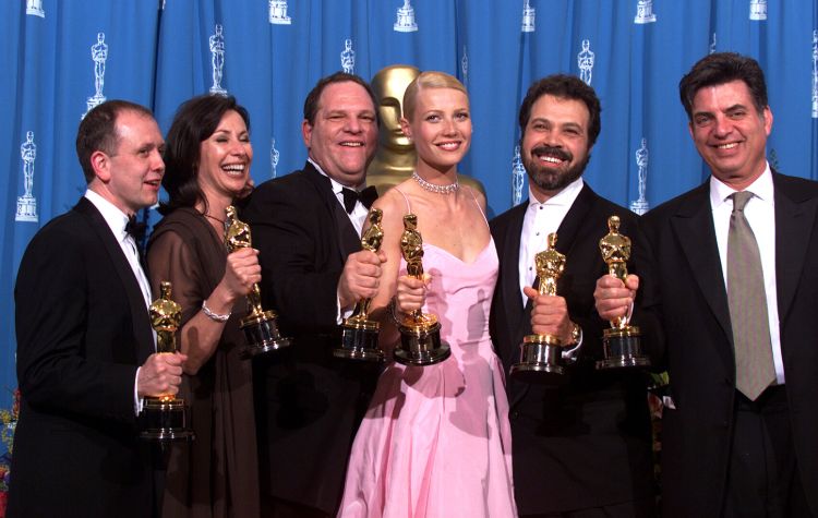Oscar -pristagare tillsammans med harvey Weinstein står på scenen