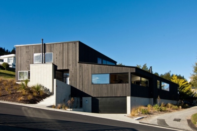 Arkitekthusdesign exteriör cederträ svart väggbeklädnad byggd på sluttningen