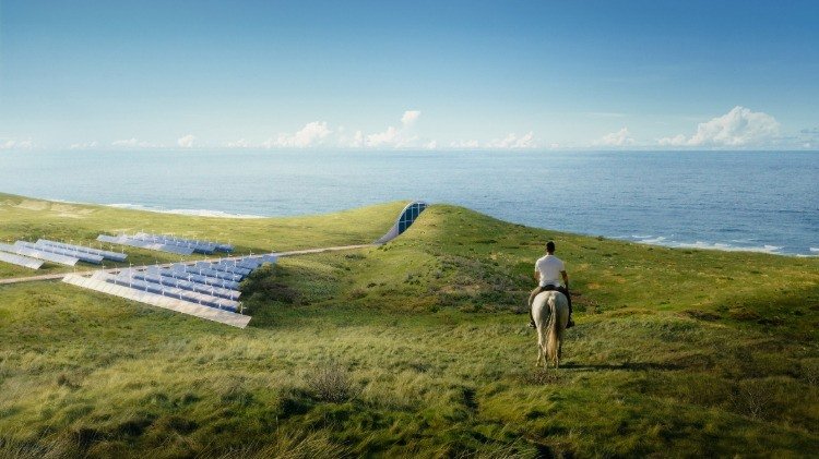 mini vindkraftverk och solpaneler förser ett hus på sanddynen med energi och vatten