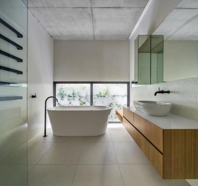 Badkar badrum sparsamt uppsatt handfat underskåp lång spegel