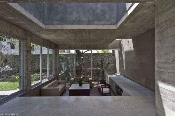 Betong- och glashus med ett modernt designat vardagsrum
