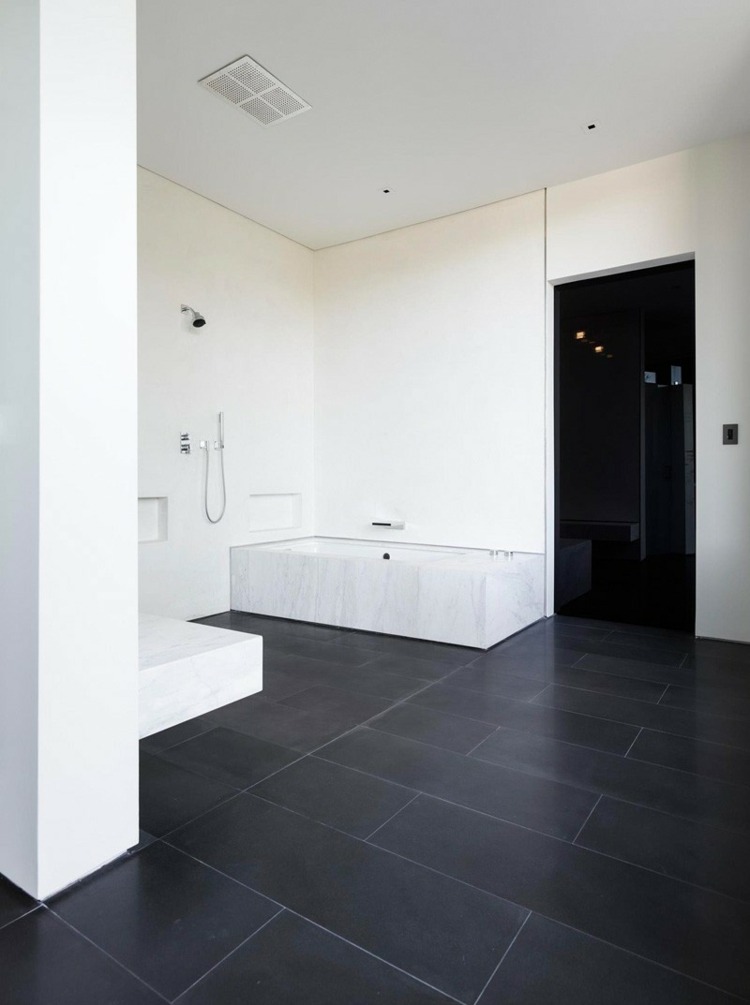 betonghus glas badrum svart kakel vit vägg badkar