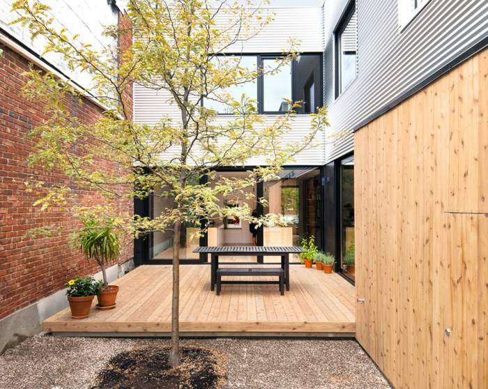 design hus bostadsstruktur innergård trädgård terrass träd växter trä trädgårdsmöbler