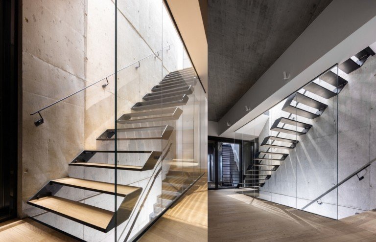 Interiörarkitektur med synliga betongväggar och en trappa av trä- och metallräcken