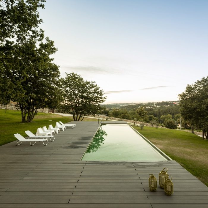 hus terrass trägolv pool solstolar utsikt över trädgården