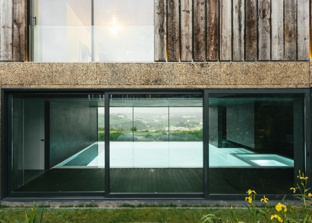 Pool betongväggar glasfasad fin utsikt över trädgården