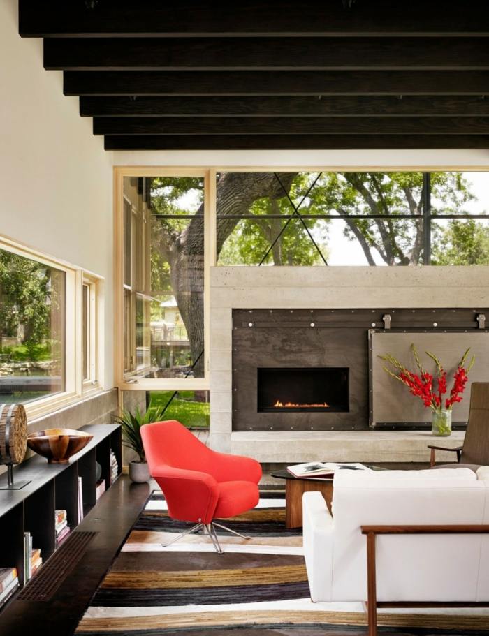 modernt vardagsrum vit soffa fåtölj röd öppen spis fönster