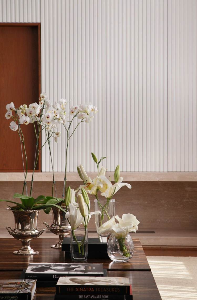husinteriör i orkidéliljor i vitt och mörkt trä