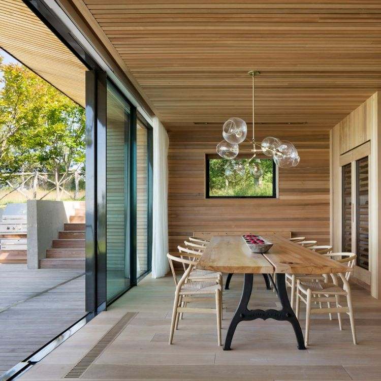 hus med träpanel design minimalistisk trägolv matbord trästolar skjutbara glasdörrar