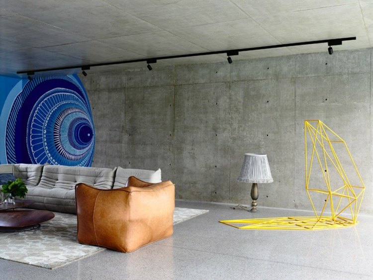 modernt vardagsrum design vägg betong look soffa fåtölj matta
