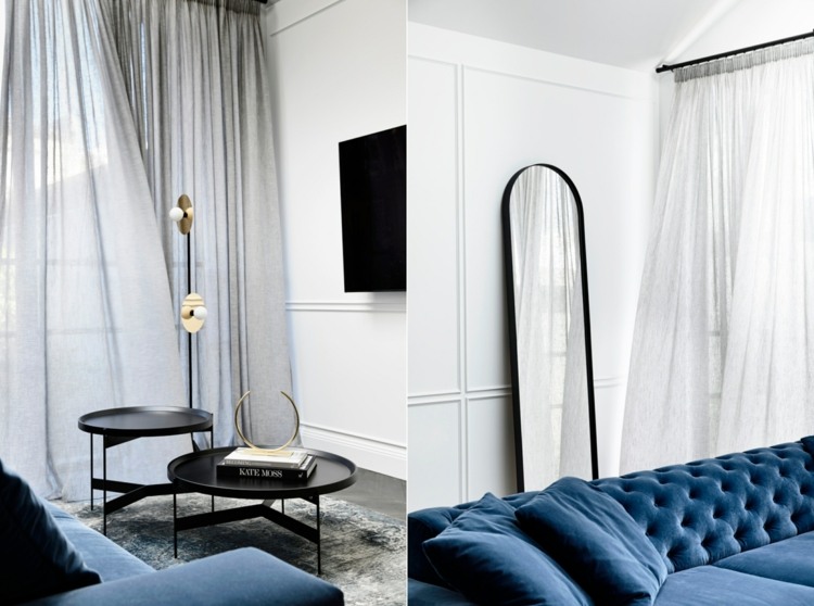 ljust vardagsrum med blå soffa och vit väggbeklädnad