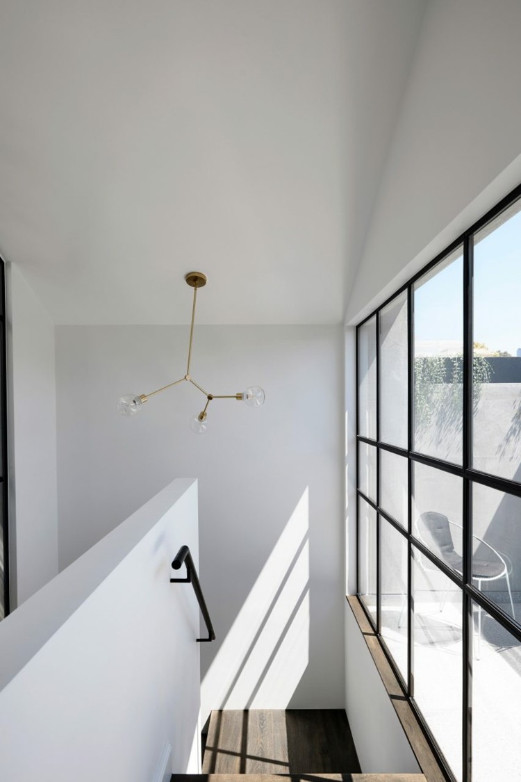 enkelt trapphus med stora fönster och accenter i svart metall