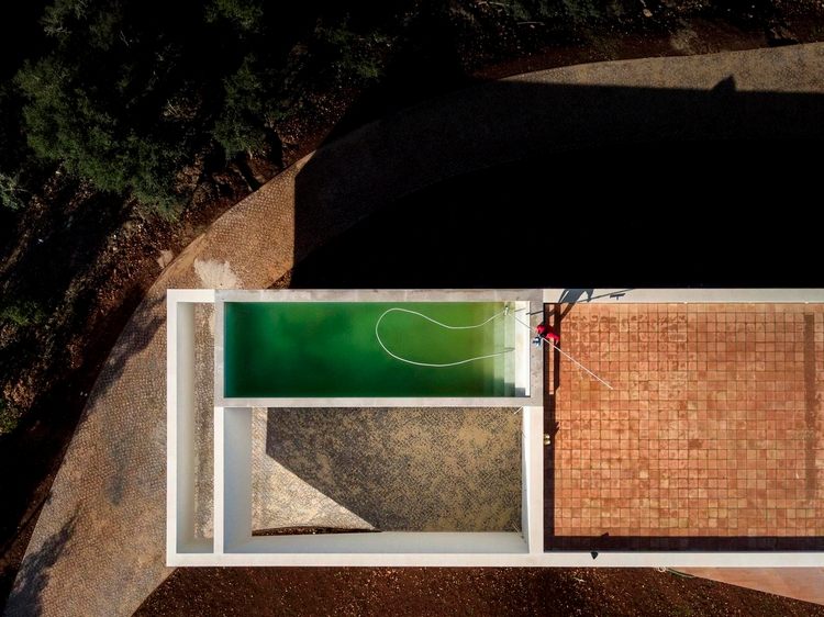 kantiga former med en pool på taket av huset täckt med kakel och betongväggar