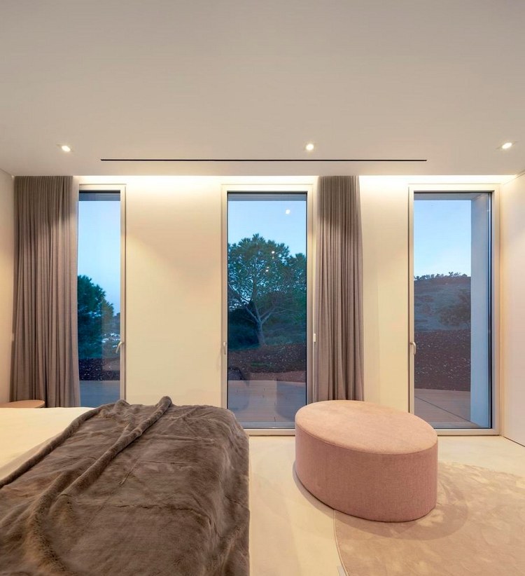 minimalistiskt sovrum med tre glasdörrar från golv till tak och takbelysning