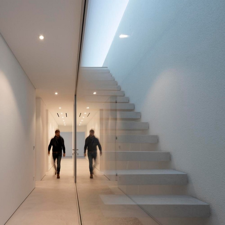 trappa med skjutdörr i glas och lång korridor med vita väggar