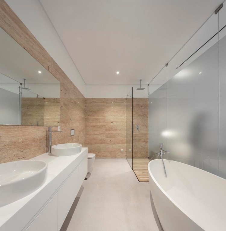badrum med speglad duschkabin, dubbla handfat och badkar, stilfullt designat