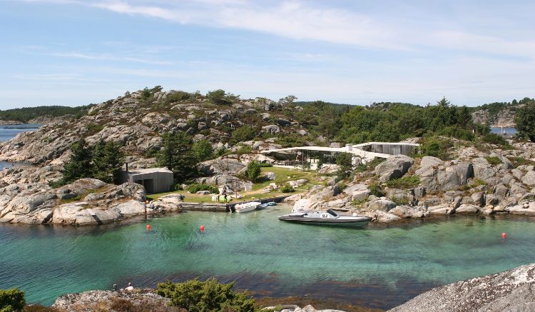 hus med tak tak fjord hus design stenar landskap omgivning fågel utsikt motorbåt klart vatten strand