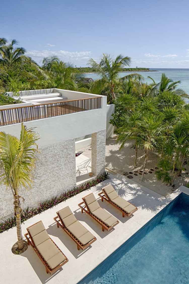 hus med rustikt poolområde solstolar palmer terrass