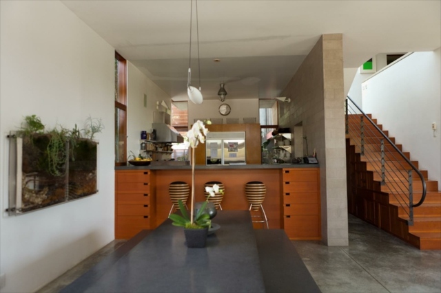 Träö kök form inbyggda garderober trätrappor betongväggar matbord