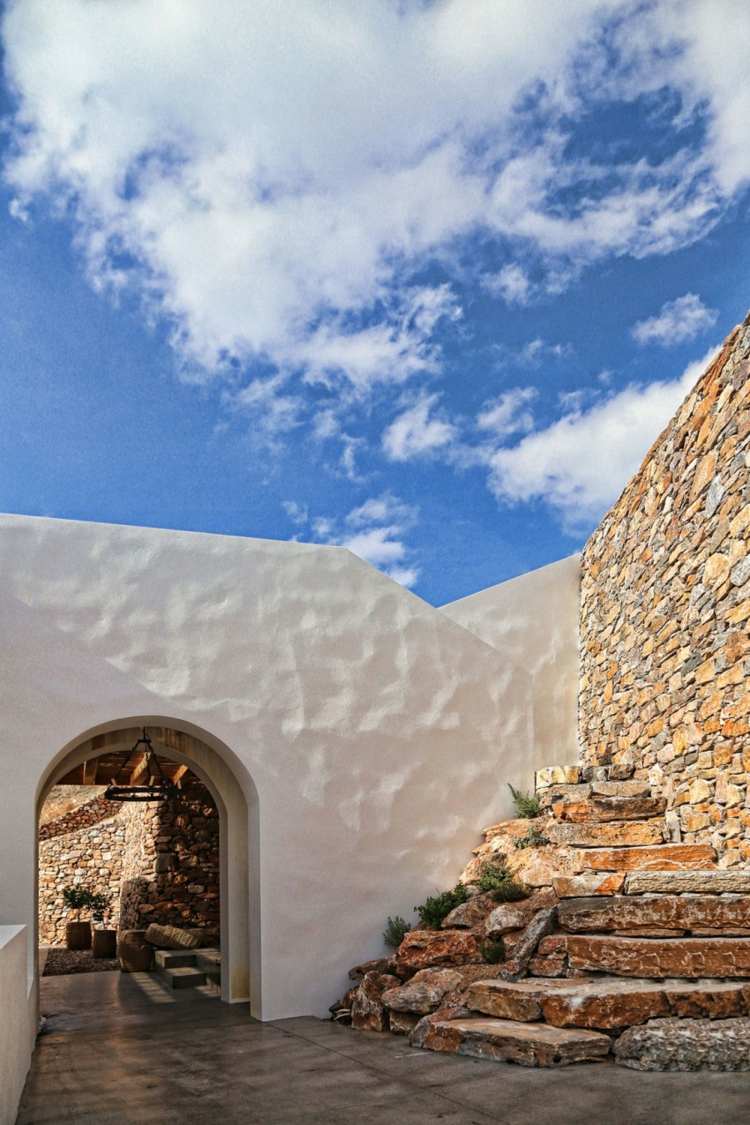 hus med vit och sten fasad dekoration innergård ingång båge