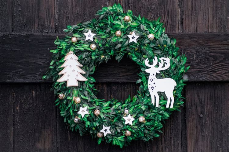 Dekorera till jul en dörrkrans av naturmaterial som eukalyptus och med hemlagad julgransdekoration av papper