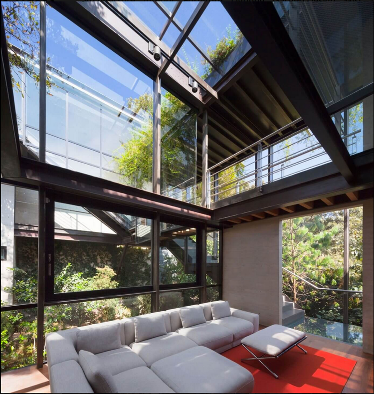 husfasad-glas-modern-estetik-interiör-soffa-grå-natur-glastak