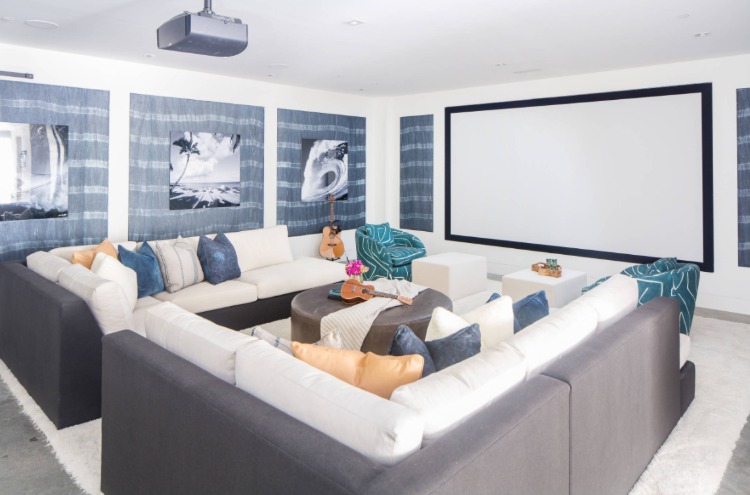 ljust rum med skärm och hemmabioprojektor ovanför en bekväm soffa i taket
